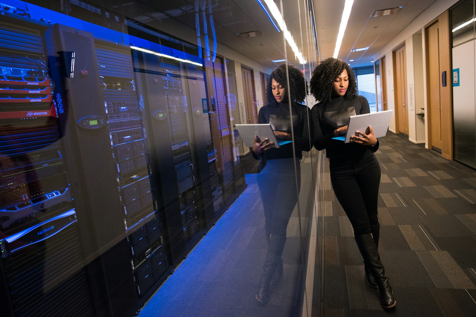 Professional walking past server racks in a data center